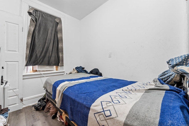 bedroom with lofted ceiling and hardwood / wood-style flooring