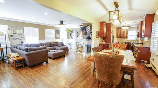 dining area featuring ceiling fan, a fireplace, wood finished floors, and recessed lighting