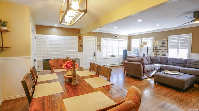 dining area with beam ceiling, ceiling fan, a baseboard radiator, crown molding, and hardwood / wood-style floors