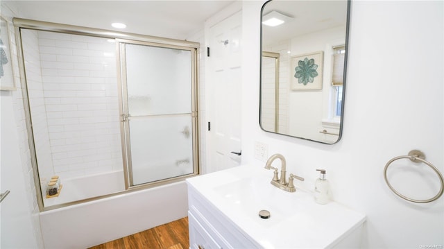 bathroom featuring hardwood / wood-style floors, vanity, and combined bath / shower with glass door