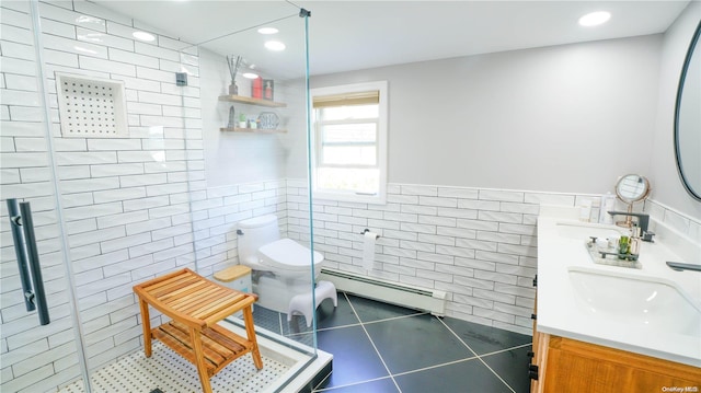 bathroom featuring tile patterned floors, vanity, baseboard heating, tile walls, and toilet