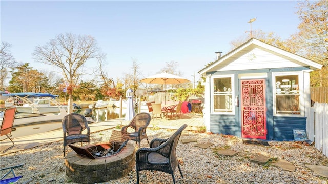 view of outdoor structure featuring a water view and an outdoor fire pit