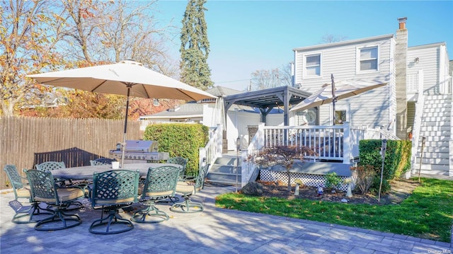 rear view of property featuring a gazebo and a wooden deck