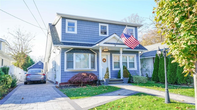 view of front of home with a shingled roof and fence