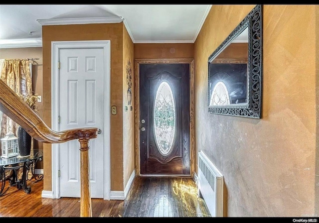 foyer entrance with radiator heating unit, ornamental molding, plenty of natural light, and hardwood / wood-style flooring