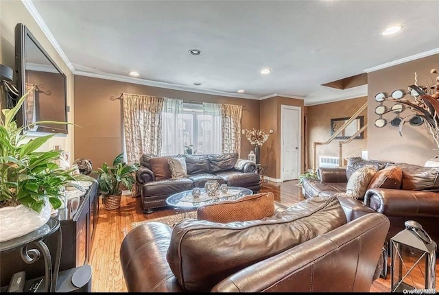 living room with a wealth of natural light, hardwood / wood-style floors, and crown molding