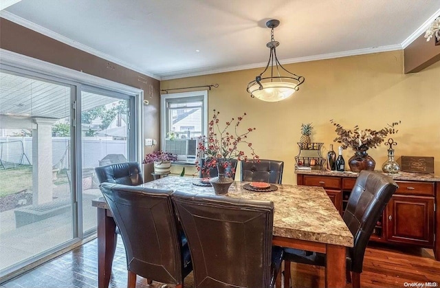 dining area featuring ornamental molding and dark wood-type flooring