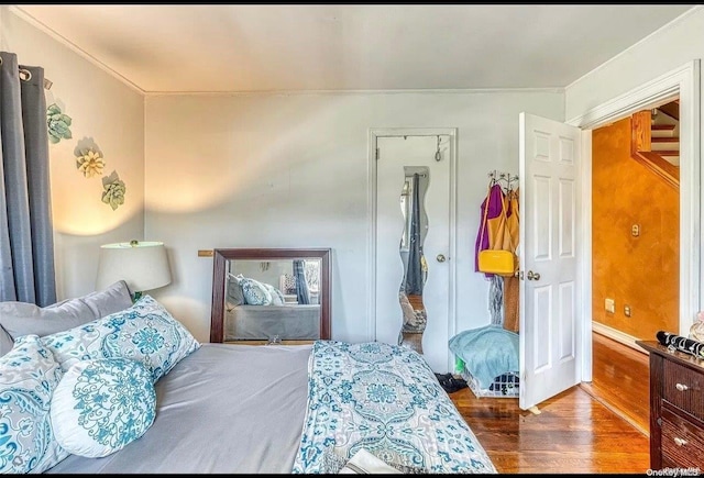 bedroom with hardwood / wood-style flooring and ornamental molding