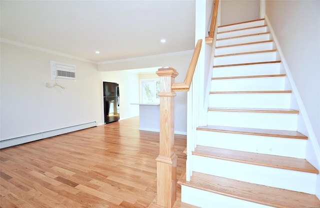 staircase featuring wood finished floors, ornamental molding, a wall unit AC, recessed lighting, and baseboards