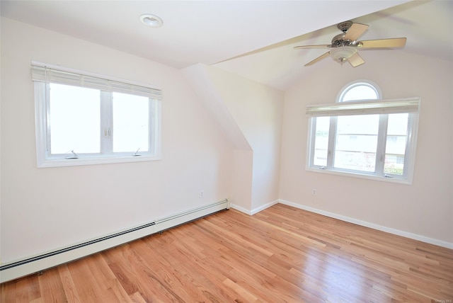 additional living space featuring baseboard heating, light wood-style flooring, vaulted ceiling, baseboards, and ceiling fan