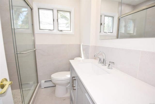 full bathroom with a baseboard radiator, a stall shower, tile patterned floors, vanity, and tile walls