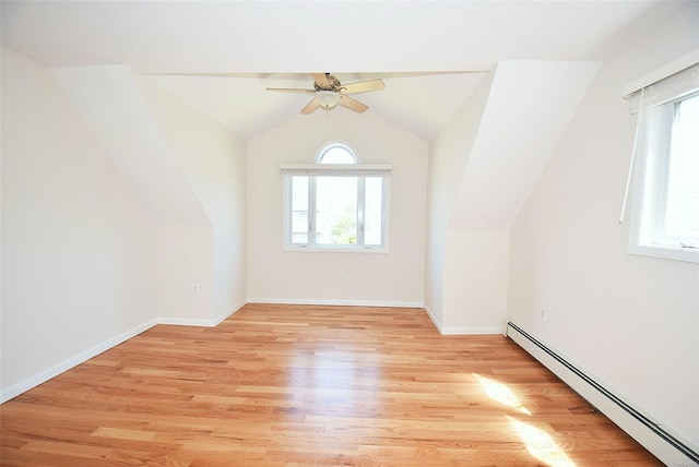 additional living space with baseboard heating, ceiling fan, light wood-style floors, lofted ceiling, and baseboards