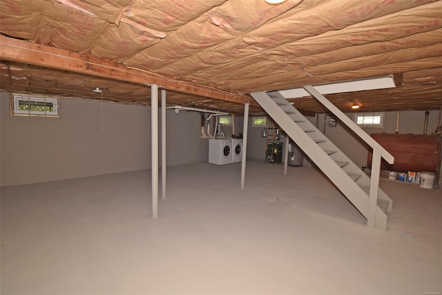 basement featuring independent washer and dryer, stairway, healthy amount of natural light, and water heater