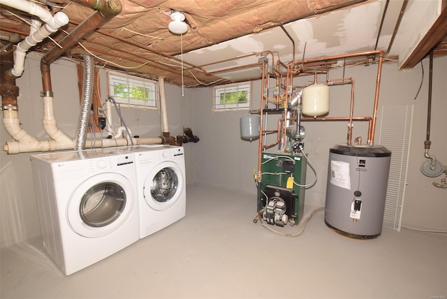 clothes washing area featuring water heater, separate washer and dryer, and a heating unit