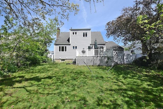 rear view of house featuring a wooden deck, a chimney, and a shingled roof