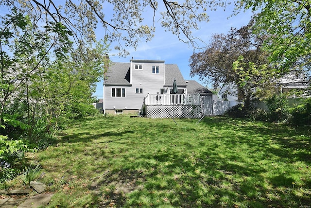 rear view of house featuring a wooden deck and roof with shingles