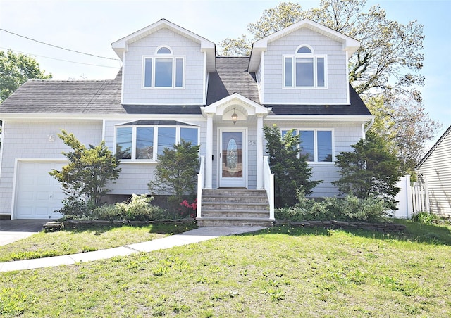 traditional-style home with a front lawn, a shingled roof, an attached garage, and entry steps