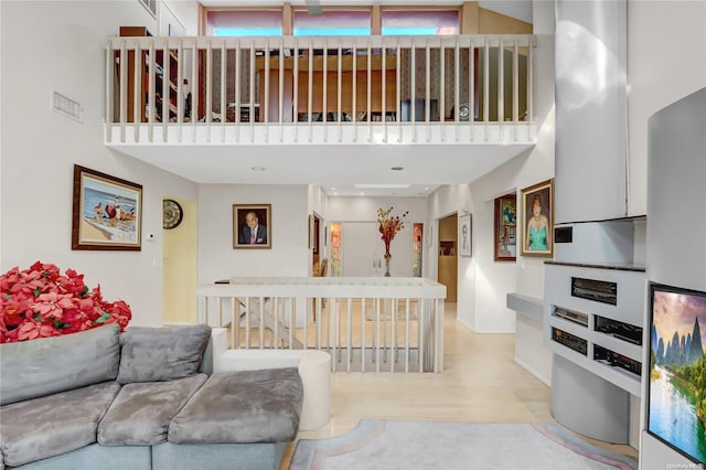 living room with a high ceiling and light hardwood / wood-style floors