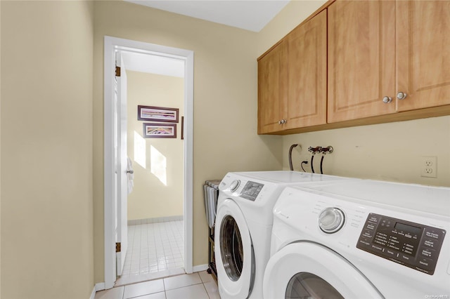 laundry room with separate washer and dryer, light tile patterned floors, and cabinets