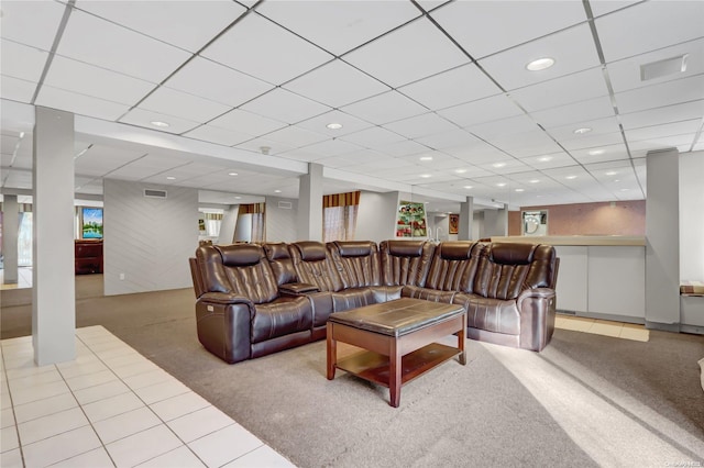 living room with a drop ceiling and carpet