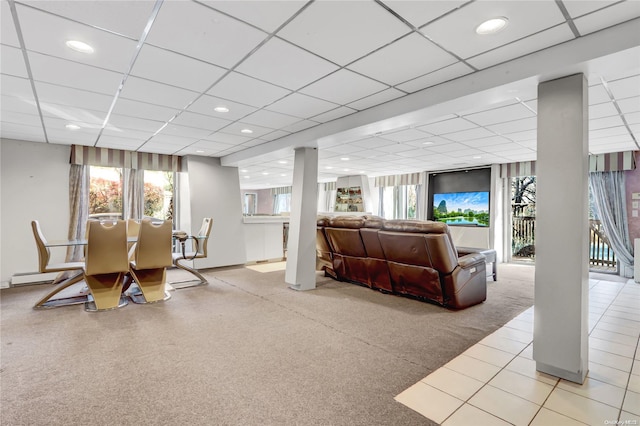 living room with a paneled ceiling and light colored carpet