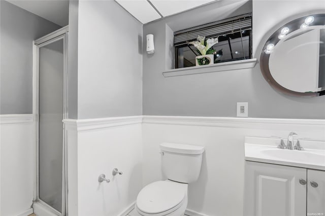 bathroom featuring toilet, vanity, and walk in shower