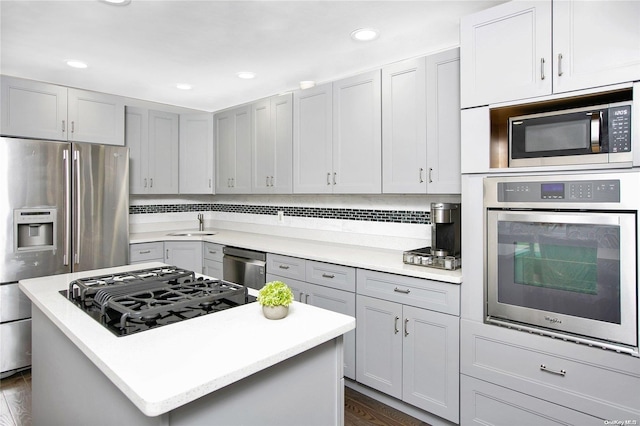 kitchen featuring gray cabinets, a kitchen island, stainless steel appliances, and dark wood-type flooring