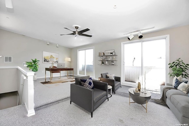 carpeted living room with ceiling fan and rail lighting