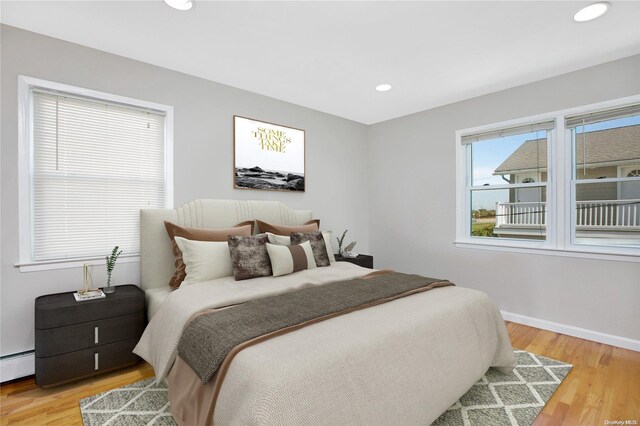 bedroom with light wood finished floors, recessed lighting, and baseboards