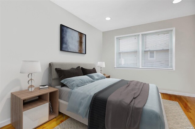 bedroom featuring baseboards, light wood finished floors, and recessed lighting