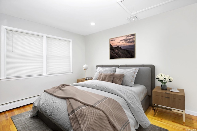 bedroom with wood-type flooring and a baseboard radiator