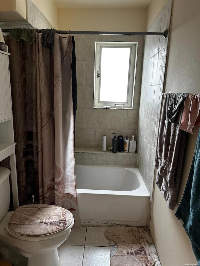 bathroom with tile patterned floors, toilet, and shower / bath combo with shower curtain