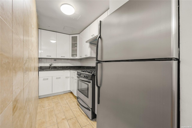 kitchen with sink, white cabinets, light wood-type flooring, and appliances with stainless steel finishes