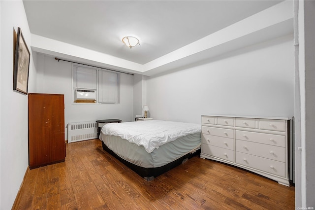 bedroom featuring radiator heating unit and wood-type flooring