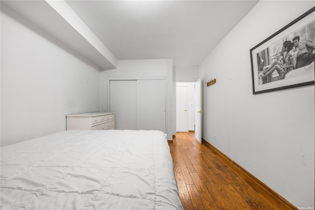 bedroom with a closet and dark hardwood / wood-style floors