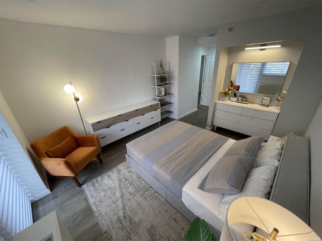 bedroom with dark wood-type flooring