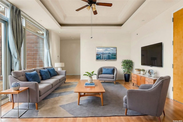 95-08 65th Rd Unit 7A, Rego Park, NY 11374 - living area with light wood finished floors, a tray ceiling, and a ceiling fan