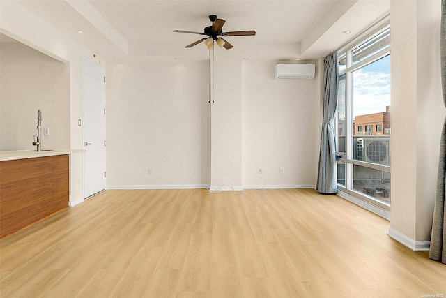 unfurnished room with a wall mounted AC, ceiling fan, cooling unit, and light hardwood / wood-style floors