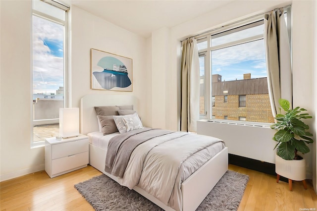 bedroom featuring multiple windows and light hardwood / wood-style flooring