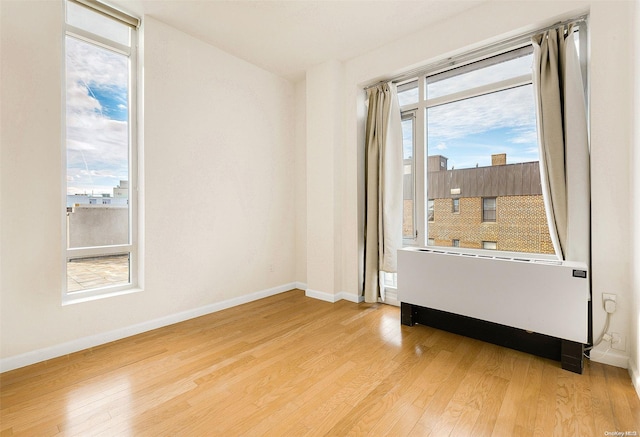 spare room with light hardwood / wood-style flooring and radiator