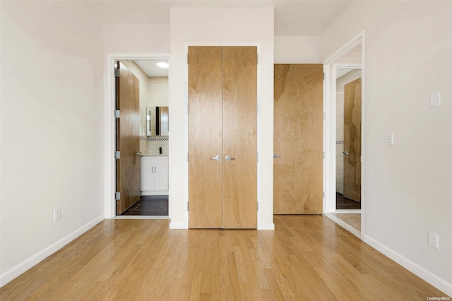 95-08 65th Rd Unit 7A, Rego Park, NY 11374 - unfurnished bedroom featuring light wood finished floors, baseboards, and connected bathroom