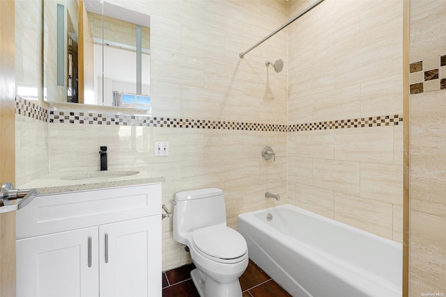 full bathroom featuring vanity, tiled shower / bath combo, tile walls, and toilet