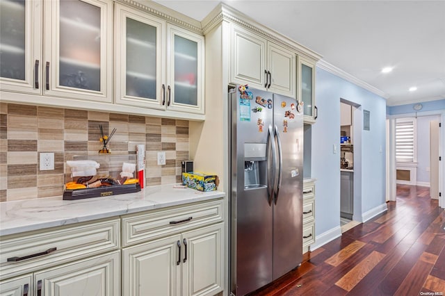 kitchen with tasteful backsplash, stainless steel fridge with ice dispenser, dark hardwood / wood-style flooring, crown molding, and cream cabinets