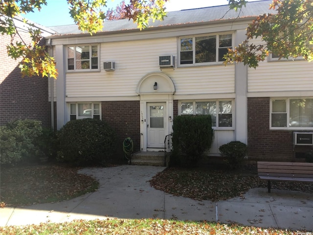 view of front of property with an AC wall unit