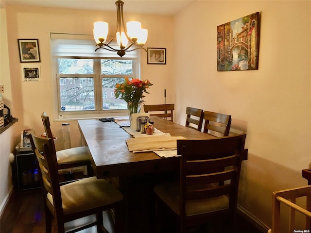 dining area featuring dark hardwood / wood-style flooring and an inviting chandelier