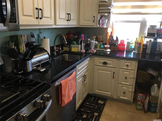 kitchen with light tile patterned floors, stainless steel appliances, and sink