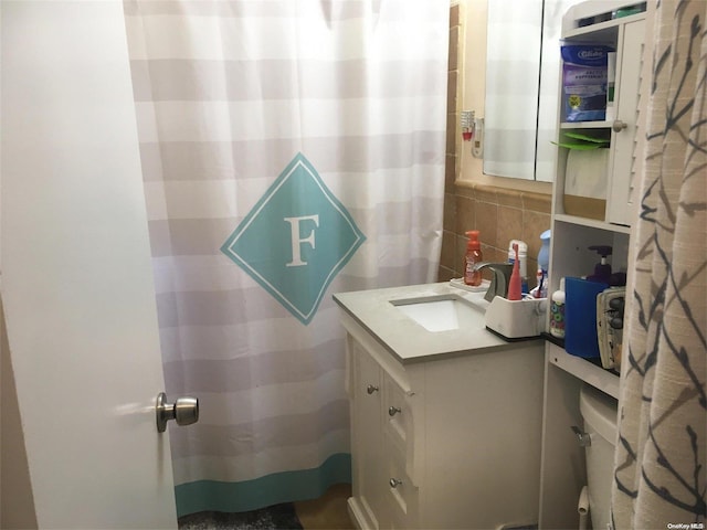 bathroom featuring decorative backsplash, vanity, and toilet