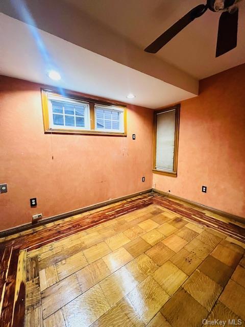 basement featuring ceiling fan and plenty of natural light