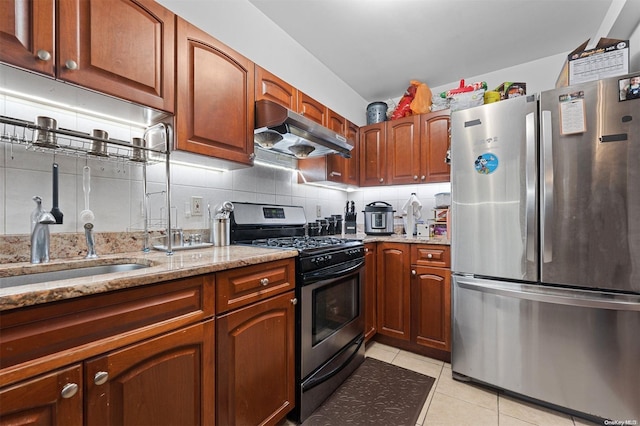 kitchen featuring sink, light stone counters, decorative backsplash, light tile patterned flooring, and appliances with stainless steel finishes