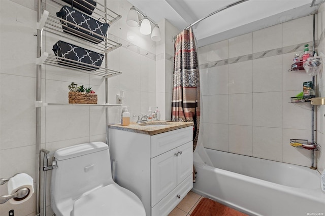 full bathroom featuring tile patterned flooring, toilet, shower / bath combo with shower curtain, vanity, and tile walls